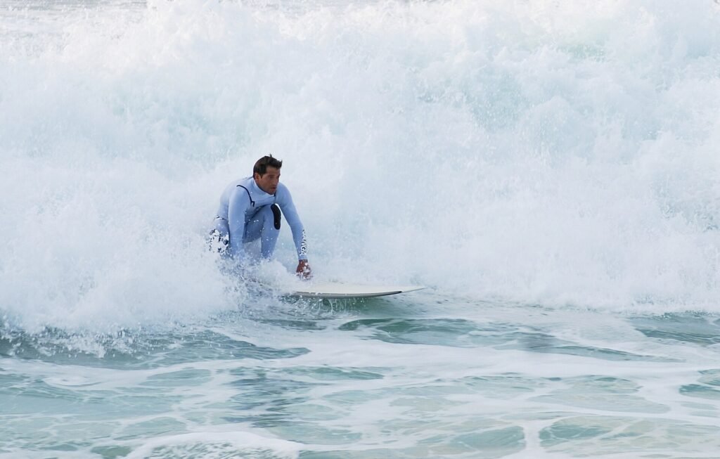 Surfers en badgasten op het lange zandstrand van Costa da Caparica