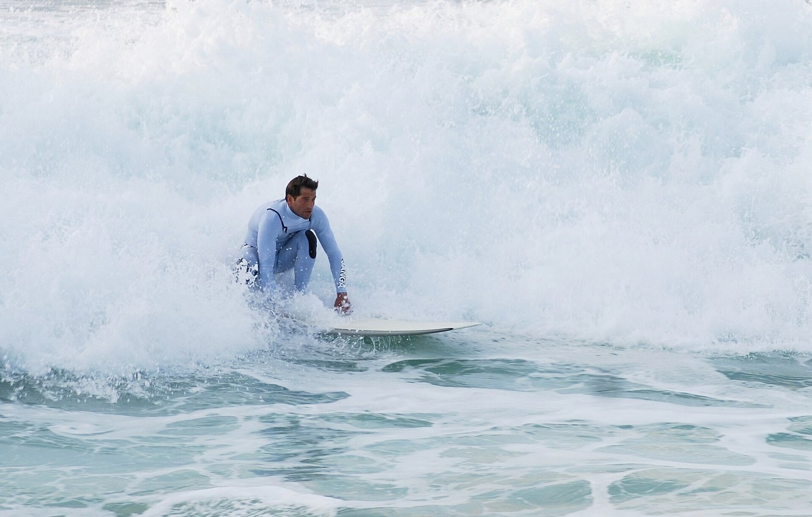 Surfers en badgasten op het lange zandstrand van Costa da Caparica