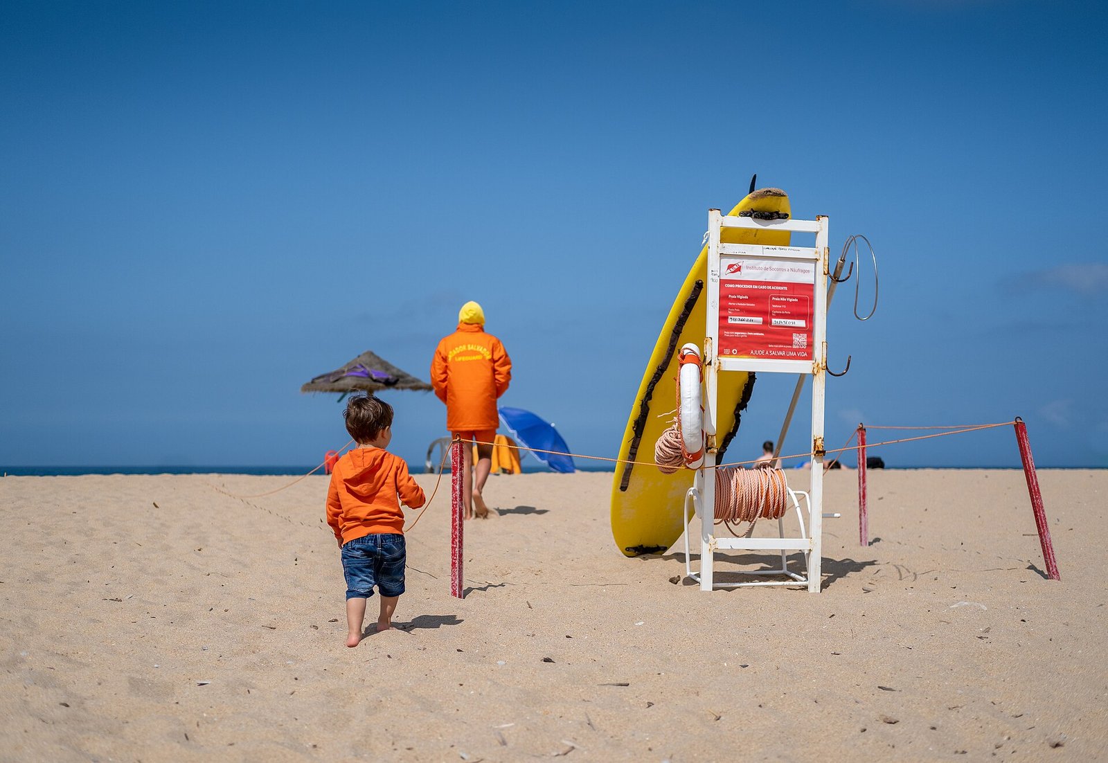 Surfers wachten op een golf voor de rotsachtige kust bij Ericeira