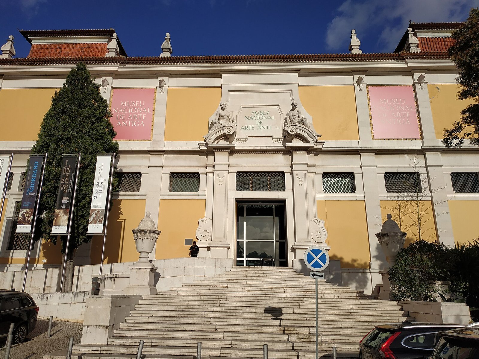Bezoekers lopen naar de ingang van een klassiek museumgebouw in Lissabon