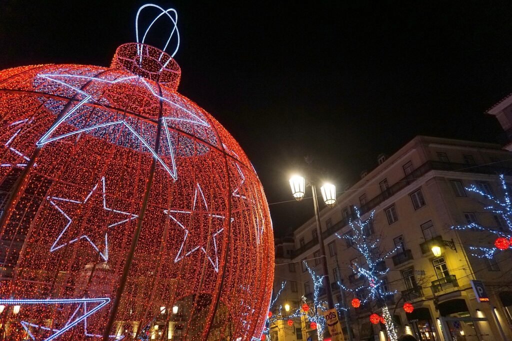 Straat met feestelijke kerstverlichting boven het wegdek in de avond
