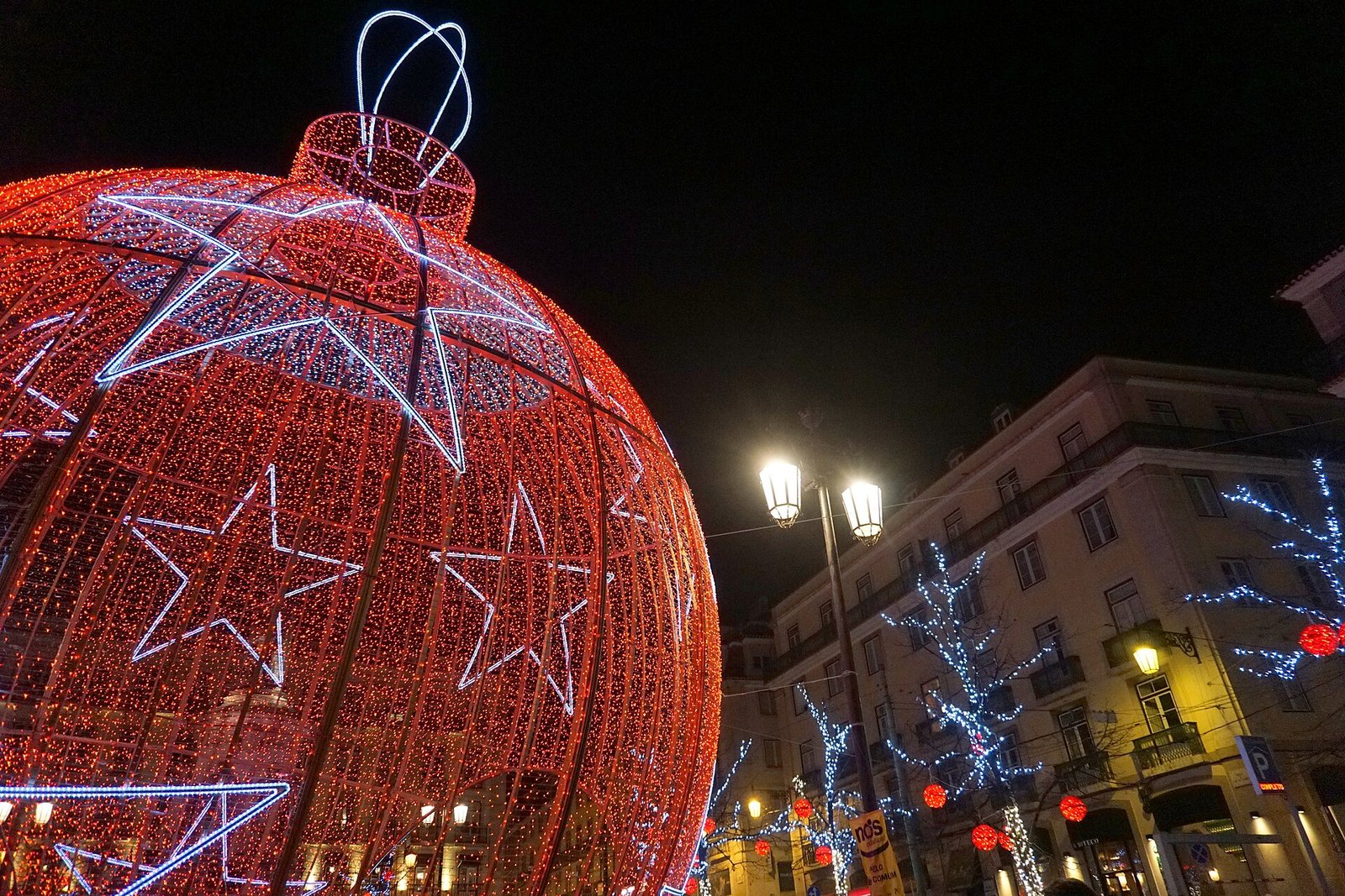 Straat met feestelijke kerstverlichting boven het wegdek in de avond