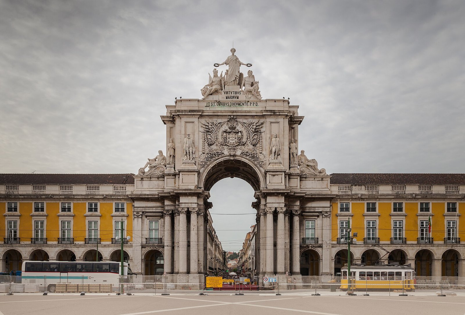 Zonnig plein met gele arcadegebouwen aan de rivier in Lissabon