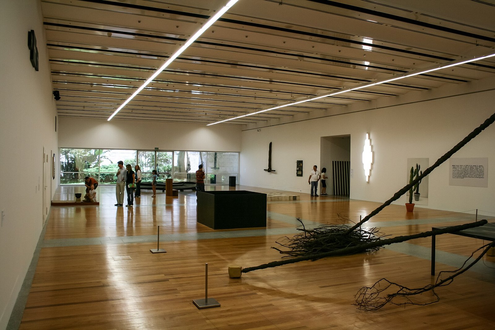 Bezoekers lopen door een lichte tentoonstellingsruimte met witte wanden