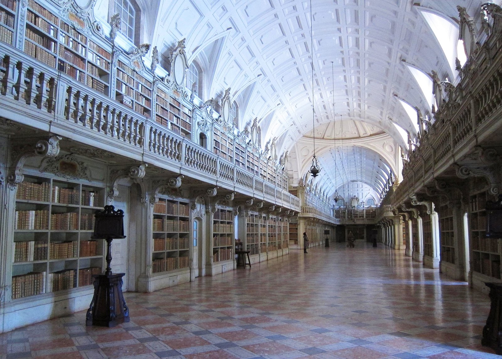 Lange barokke bibliotheekzaal met houten boekenkasten in het paleis van Mafra