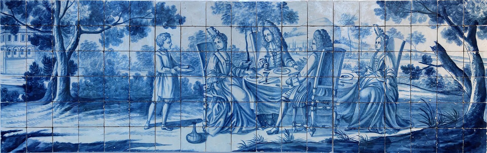 Blauwwit betegeld paneel met een uitgebreid stadstafereel en gebouwen