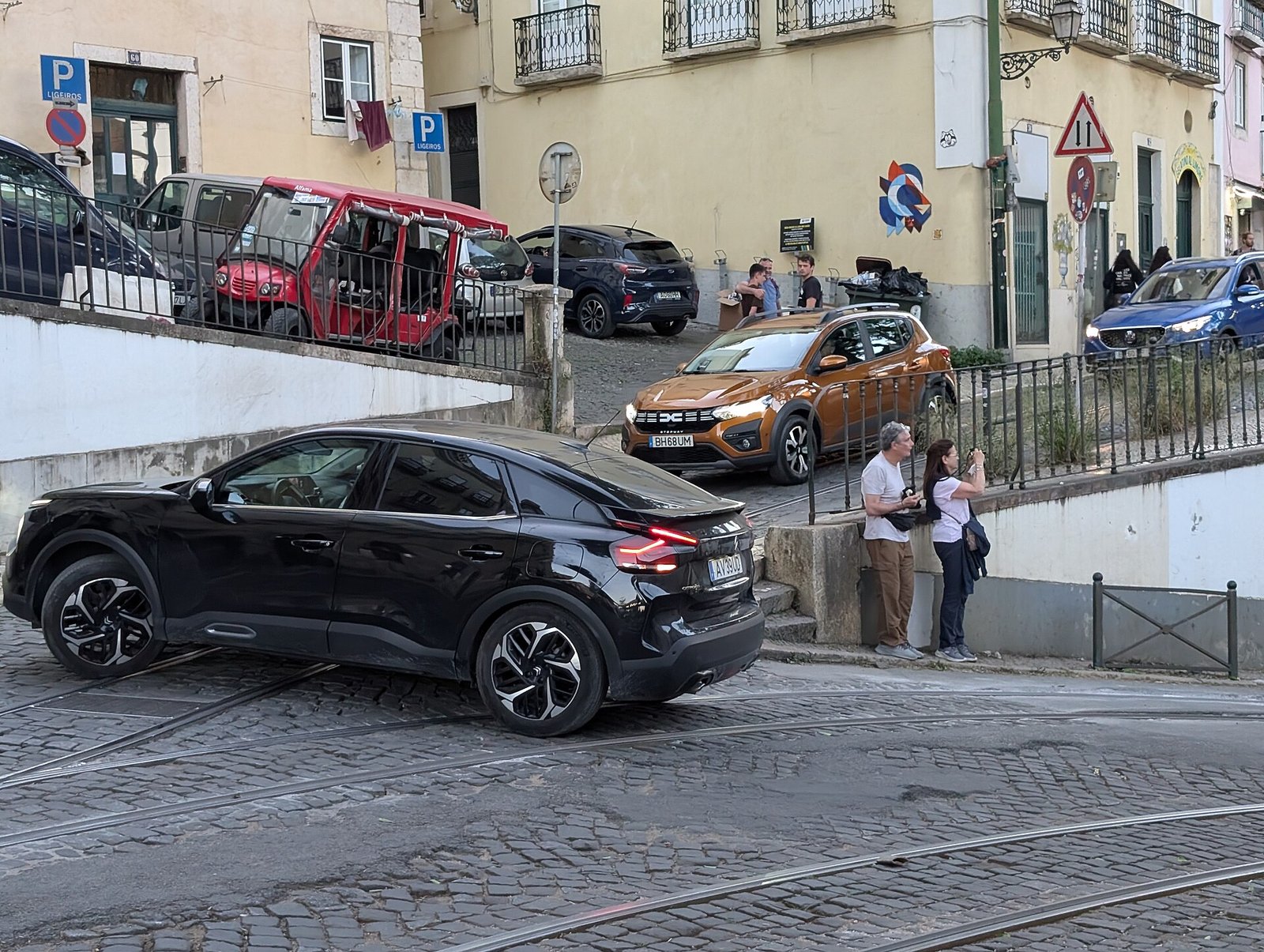 Auto's staan dicht opeen in een smalle hellende straat in Lissabon